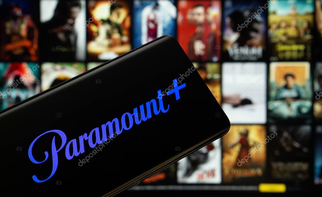 Dhaka, Bangladesh - 17 March 2025: The logo of the paramount+ is displayed on a smartphone screen, and the website paramount+ is visible on a computer screen in the background.