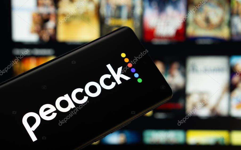 Dhaka, Bangladesh - 17 March 2025: The logo of the peacock is displayed on a smartphone screen, and the website peacock is visible on a computer screen in the background.