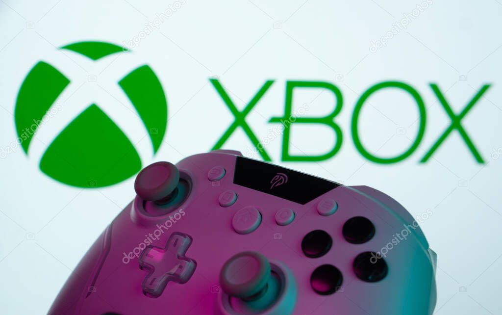 Dhaka, Bangladesh- 09 May 2025: A close-up of a white gamepad with the XBOX seen on screen in the background.