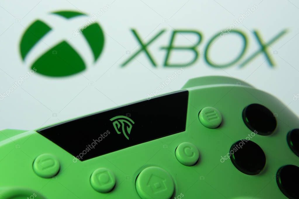 Dhaka, Bangladesh- 09 May 2025: A close-up of a white gamepad with the XBOX seen on screen in the background.