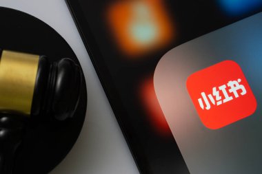 Dhaka, Bangladeş - 18 Mart 2025: Hakimin tokmağının yanında kırmızı not uygulamasını gösteren bir iPad ekranının yakın çekimi.