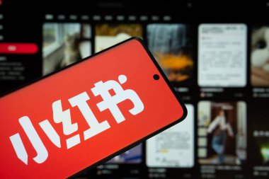Dhaka, Bangladeş - 18 Mart 2025: Kırmızı notun logosu akıllı telefon ekranında gösteriliyor ve bild.de web sitesi arka plandaki bilgisayar ekranında görülebiliyor.