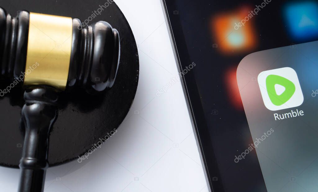 Dhaka, Bangladesh- 18 March 2025: A close up of an iPad screen displaying the rumble app alongside a judge's gavel.