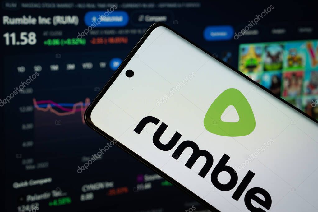 Dhaka, Bangladesh- 18 March 2025: rumble logo is displayed on a smartphone screen, with a stock graph webpage visible on a computer screen in the background.