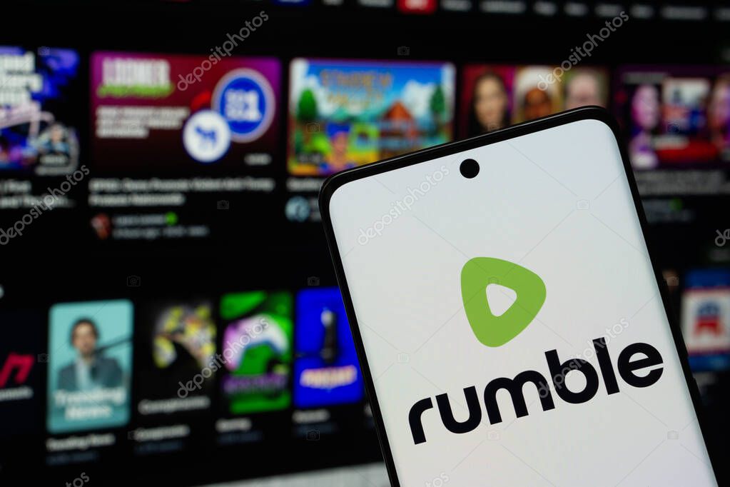 Dhaka, Bangladesh - 18 March 2025: The logo of the rumble is displayed on a smartphone screen, and the website rumble is visible on a computer screen in the background.