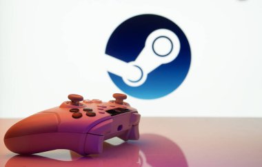 Dhaka, Bangladeş - 03 Haziran 2025: Steam logosu önünde beyaz bir arkaplanda oyun denetleyici.