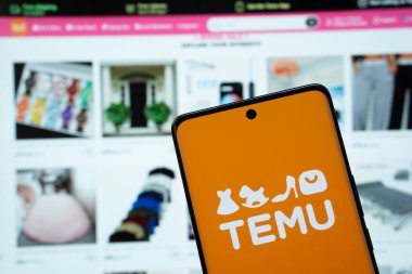 Dhaka, Bangladeş - 18 Mart 2025: Temu logosu akıllı telefon ekranında gösteriliyor ve temu web sitesi arka planda bir bilgisayar ekranında görülebiliyor.