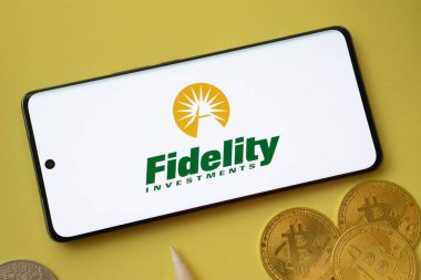 Dhaka, Bangladeş - 12 Haziran 2025: Fidelity Investments logosu Bitcoin paralarının sarı arka planda sergilendiği akıllı bir telefonda sergileniyor
