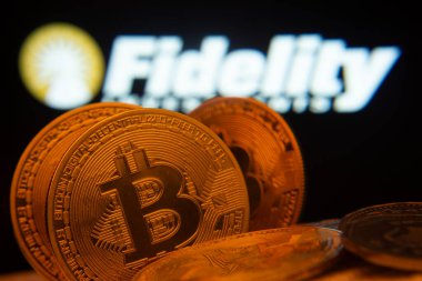 Dhaka, Bangladeş - 12 Haziran 2025: Fidelity Investments logosu arka planda görünen Bitcoin paralarının yakın çekimi.