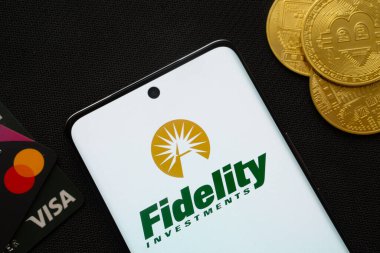 Dhaka, Bangladeş - 12 Haziran 2025: Fidelity Investments logosu Bitcoin paraları ve ödeme kartlarıyla çevrili akıllı telefon.