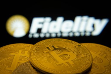 Dhaka, Bangladeş - 12 Haziran 2025: Fidelity Investments logosu arka planda görünen Bitcoin paralarının yakın çekimi.