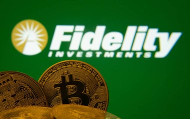 Dhaka, Bangladeş - 12 Haziran 2025: Fidelity Investments logosu arka planda görünen Bitcoin paralarının yakın çekimi.