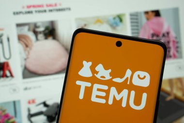 Dhaka, Bangladeş - 18 Mart 2025: Temu logosu akıllı telefon ekranında gösteriliyor ve temu web sitesi arka planda bir bilgisayar ekranında görülebiliyor.