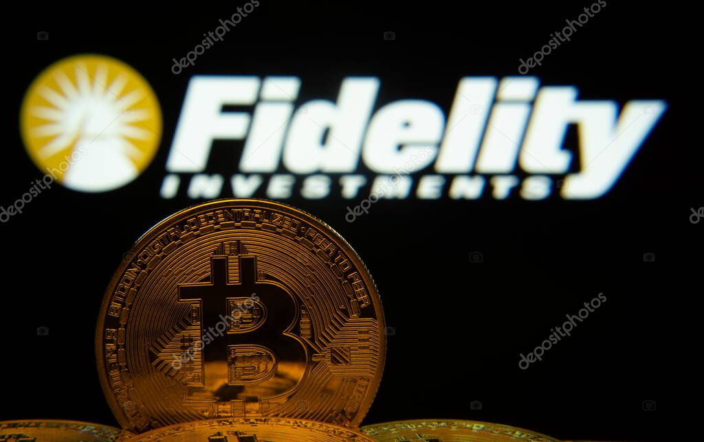 Dhaka, Bangladesh- 12 June 2025: Close-up of Bitcoin coins with the Fidelity Investments logo visible on a screen in the background.