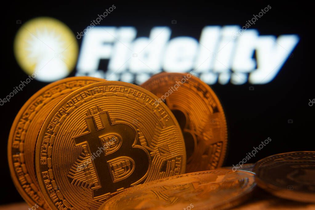 Dhaka, Bangladesh- 12 June 2025: Close-up of Bitcoin coins with the Fidelity Investments logo visible on a screen in the background.