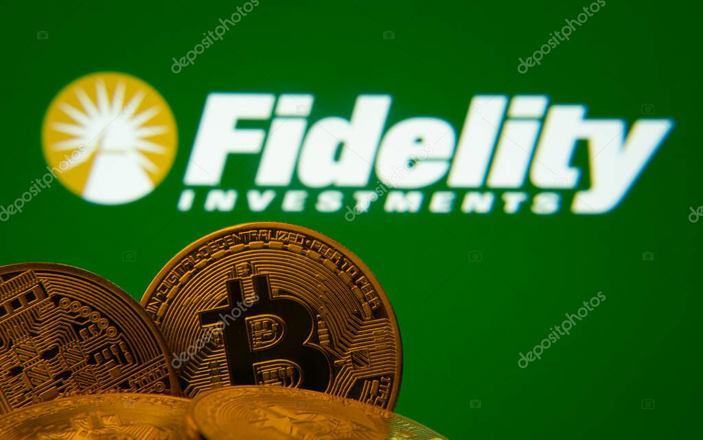 Dhaka, Bangladesh- 12 June 2025: Close-up of Bitcoin coins with the Fidelity Investments logo visible on a screen in the background.