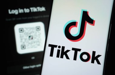 Dhaka, Bangladeş - 18 Mart 2025: tiktok logosu bir akıllı telefon ekranında gösterilir, arka planda bir bilgisayar ekranında tiktok giriş sayfası görünür.
