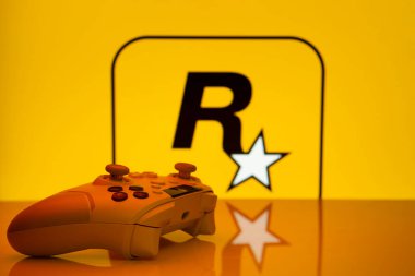 Dhaka, Bangladeş - 17 Haziran 2025: Arka planda bir rockstar oyun logosu önünde oyun denetleyici.