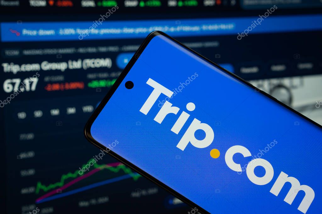 Dhaka, Bangladesh- 18 March 2025: trello logo is displayed on a smartphone screen, with a stock graph webpage visible on a computer screen in the background.