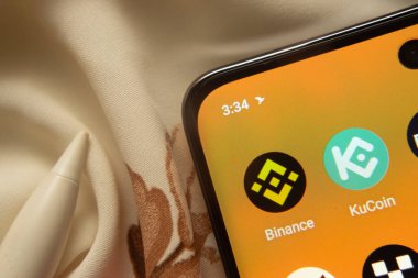 Dhaka, Bangladeş - 07 Mayıs 2025: Binance ve KuCoin uygulama simgesi akıllı telefondan görüldü.