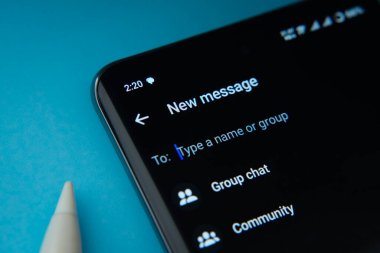 Dhaka, Bangladeş - 04 Temmuz 2025: Dhaka, Bangladeş - 17 Mart 2025: Smartphone WhatsApp yeni mesaj arayüzünü gösteren grup sohbeti ve topluluk seçenekleri mavi arka planda.