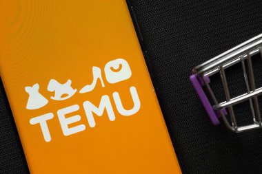 Dhaka, Bangladeş - 03 Temmuz 2025: Arka planda minyatür bir alışveriş arabasının yanında Temu logosunu gösteren bir akıllı telefon