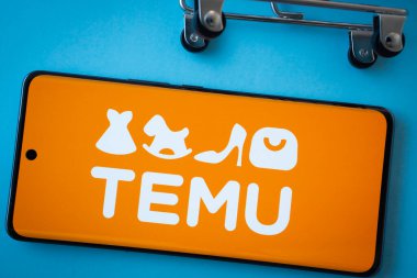 Dhaka, Bangladeş - 03 Temmuz 2025: Mavi arka planda alışveriş arabası tekerlekleri olan Temu logosunu gösteren akıllı telefon ekranı.