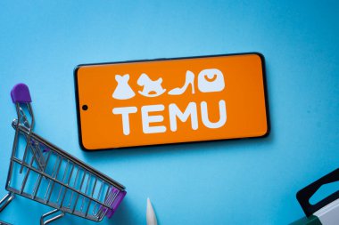 Dhaka, Bangladeş - 03 Temmuz 2025: Temu logosunu mavi arka planda alışveriş arabasıyla gösteren akıllı telefon.