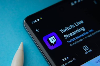 Dhaka, Bangladesh- 30 Sep 2025: On a blue surface, a smartphone displays the Twitch app within the Google Play Store.