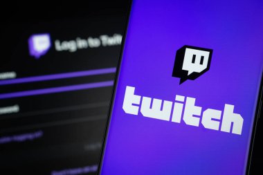 Dhaka, Bangladesh- 30 Sep 2025: Twitch logo is displayed on a smartphone screen, with the Twitch login page visible on a computer screen in the background.