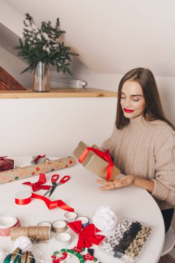 Güzel kız yılbaşı hediyelerini paketliyor. Mutlu Noeller, el yapımı, aile kutlaması