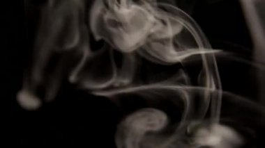 Siyah arka planda tütün dumanı yaklaştı.