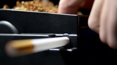 Sigara kutularına yarı otomatik bir makineyle tütün koyma süreci.
