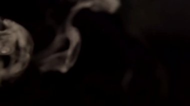 Siyah arka planda tütün dumanı yaklaştı. 