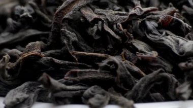 Kurutulmuş siyah çay yaprakları. makro fotoğrafçılık. Yavaş çekim yakın çekim. 