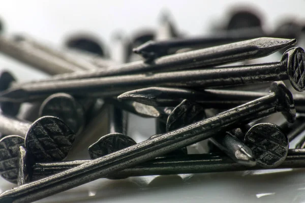 Bir avuç küçük inşaat çivisi. makro fotoğrafçılık. Yavaş çekim yakın çekim. Sanayi aracı kavramı. 