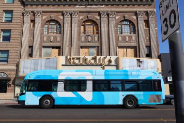 Şehir otobüsü Fresno şehir merkezindeki eski bir binanın önünde dinleniyor..