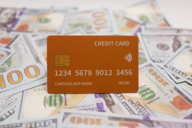 Turuncu kredi kartı, finansal başarıyı, yeniliği ve üst düzey bankacılık hizmetlerini sembolize eden ABD banknotlarının üzerine yerleştirilmiş..
