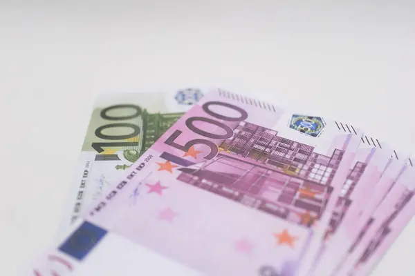 Mor ve yeşil banknotlar düzgünce istiflenmiş, Avrupa para birimi, finans ve uluslararası ekonomik işlemleri sembolize etmektedir.