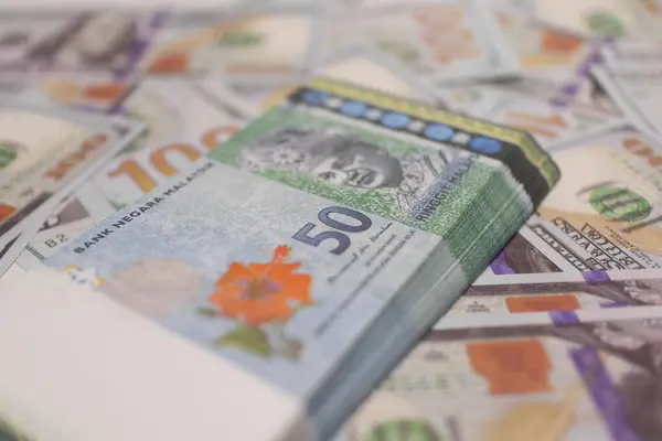 Küresel finans, döviz kurları ve finans piyasalarının altını çizerek ABD dolarlarının tepesine yığılmış Yeşil Malezya Ringgit.