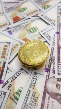Dolar banknotlarının üzerine yerleştirilen bitcoin para, kripto para ve finansal kavramları sembolize eder.