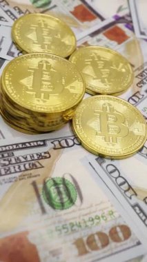 Dolar banknotları üzerine istiflenmiş bitcoinler, dijital para birimi ve geleneksel finans kavşağını sembolize ediyor.