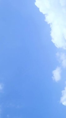 Açık mavi gökyüzünde yüzen büyük beyaz bir bulut doğadaki açıklığı ve özgürlüğü simgeliyor..