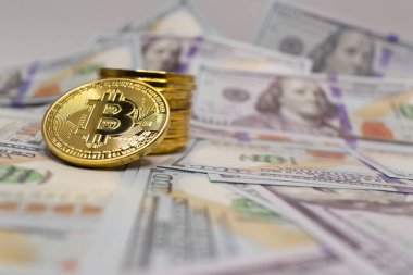 Bitcoin 100 dolarlık banknotların tepesinde, modern dijital ve geleneksel para birimi karışımını yansıtıyor.