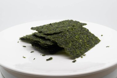 Beyaz bir tabağa yerleştirilmiş lezzetli deniz yosunları..