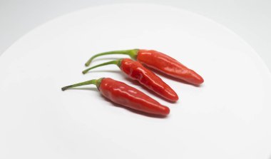 Arka planda üç taze kırmızı biber..