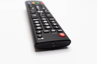 Ev kullanımı için tasarlanmış, elektronik ve medya kavramları için ideal, düz beyaz bir arka planda gösterilen, ayrıntılı bir tuş takımı düzenine sahip TV uzaktan kumandası.
