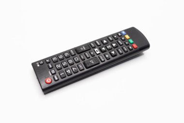 Beyaz arkaplana yerleştirilmiş siyah bir uzaktan kumandaya yakın plan, düğmeleri ve ayrıntıları gösterir.