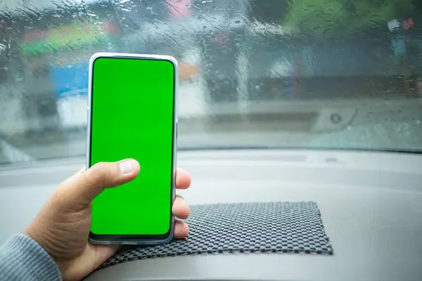 Yağmurlu bir günde yeşil ekran ile el ele tutulan yatay akıllı telefon. Uygulama tasarımı, UI görüntüleme ve modelleme amaçları için uygundur.