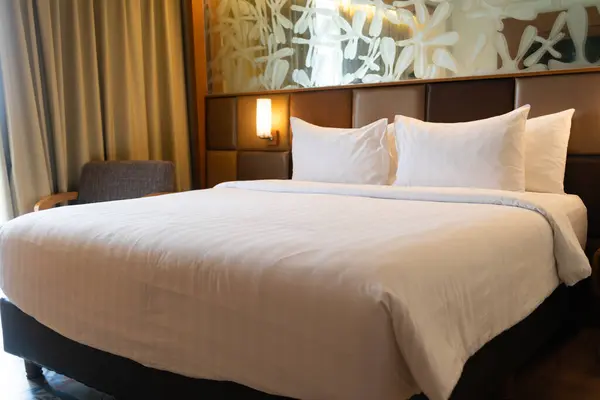 Rahat bir otel yatağı, temiz beyaz çarşaflar ve kabarık yastıklar. Rahatlamak ve iyi bir uyku çekmek için mükemmel..